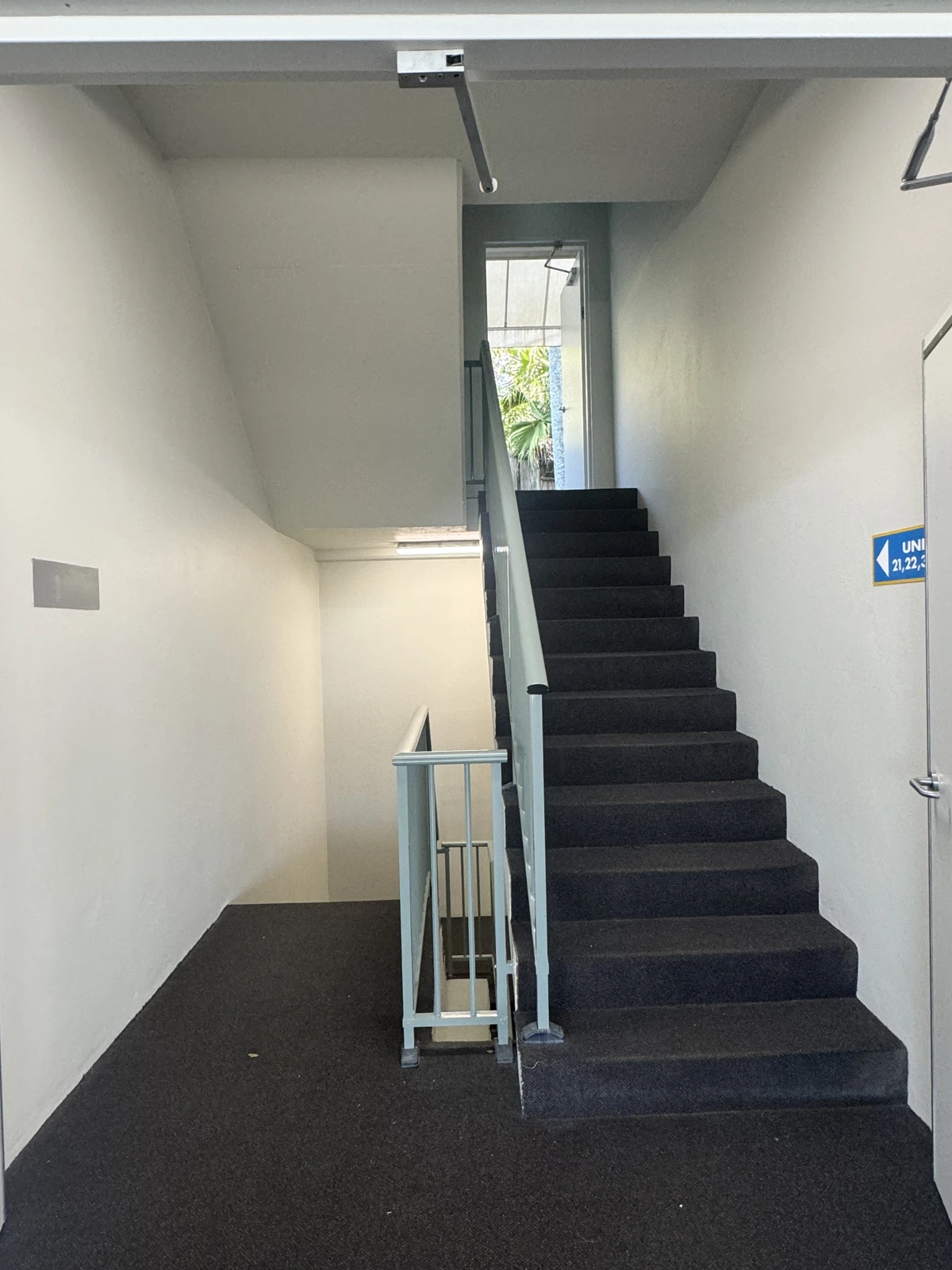Shared stairwell at Avoca Palms with painted walls, ceiling and handrail